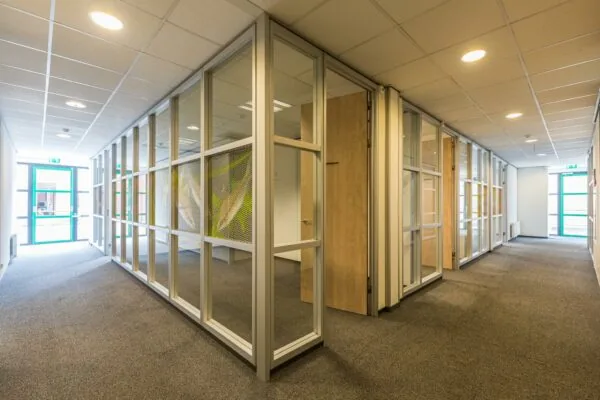 Moderne kantoorruimte aan de Laan Blussé van Oud-Alblas met glazen scheidingswanden en tapijtvloer.